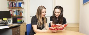 A female student and female Academic Tutor talking and looking at a leaflet together