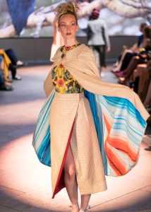 A model wearing a cloak with the fashion stripes on the catwalk