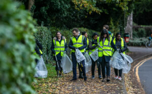 Members of University of Reading walking along a pavement litter picking