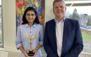 Maitreyee standing next to Reading's Vice-Chancellor holding her India 75 in 75 Award