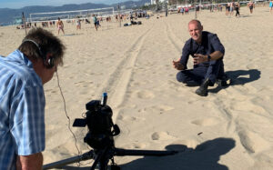 Tom Clarke reporting on sandy beach
