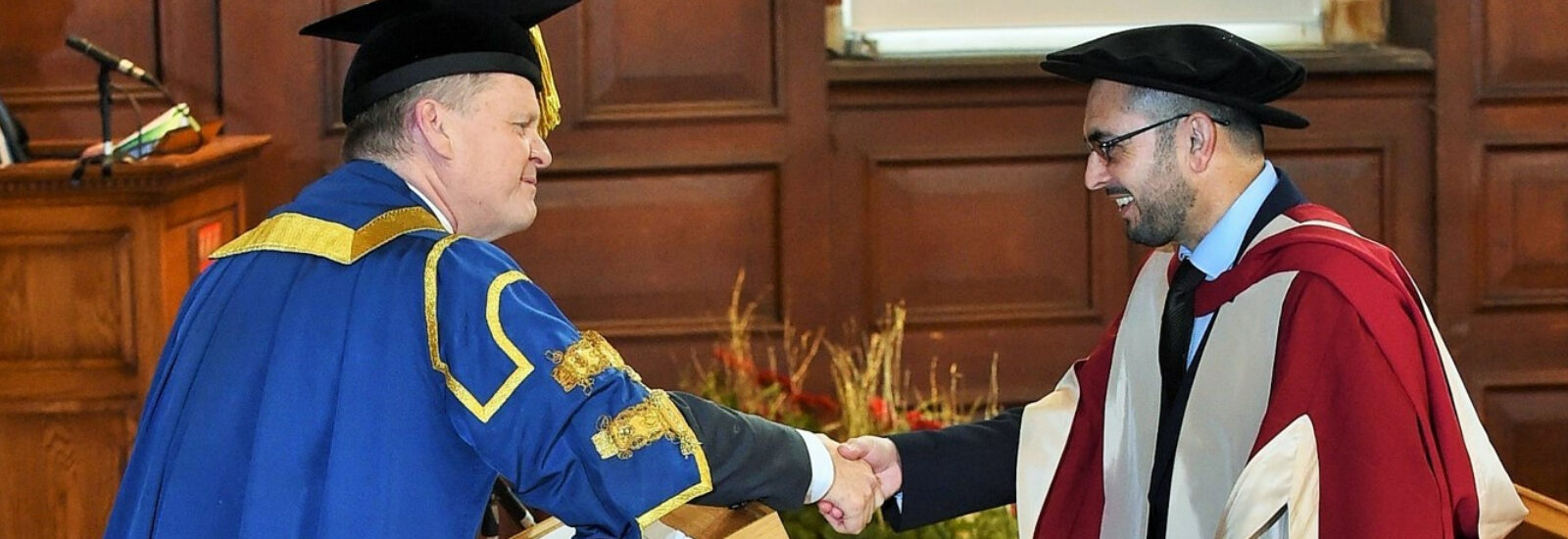 Imran shaking the Vice-Chancellor's hand on his graduation from the University of Reading