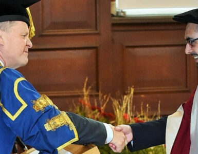 Imran shaking the Vice-Chancellor's hand on his graduation from the University of Reading
