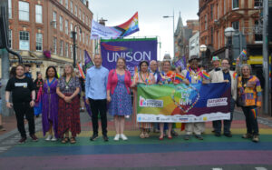 Sarah Hacker & Pride supporters standing on a rainbow zebra crossing in Reading