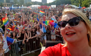 Sarah Hacker standing in front of a crowd at Reading Pride