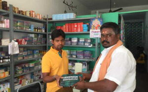 Sakthi handing out leaflets to pharmacies in India