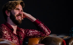 Michael Clarkson smiling, resting his head on his hand