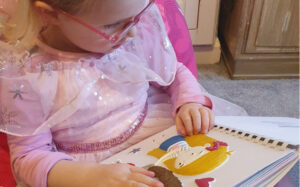 Child reading touch to see book