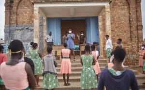 Mabel speaking in front of a crowd of girls