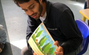 Volunteer reading book in a classroom