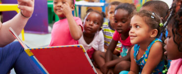 Group of primary aged schoolchildren listening to a story