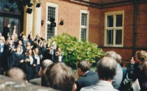 Anne and friends tossing their caps in the air at graduation