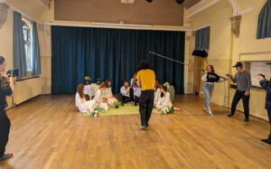 A group of students filming in a hall