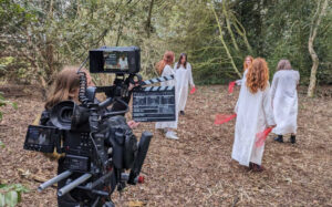 A group of students filming in a woods