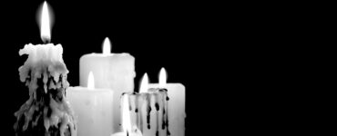 5 candles burning against a black background