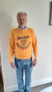 An alumni modelling a yellow University of Reading jumper which sold for £20
