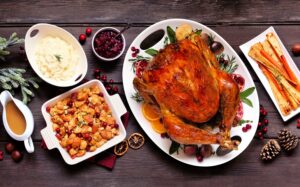 Traditional Christmas turkey dinner. Top view panoramic table scene on a dark wood banner background.
