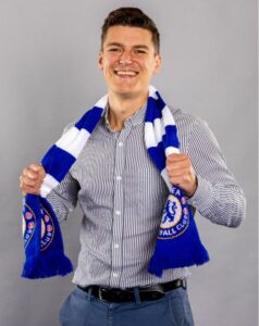 Chris smiling, wearing a Chelsea FC scarf