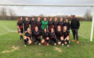 The RUWFC team standing in their kit in front of a goal