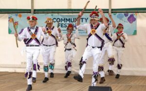A group of alumni morris dancers on stage