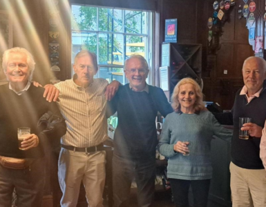 Alumni with arms around shoulders, smiling inside Park House