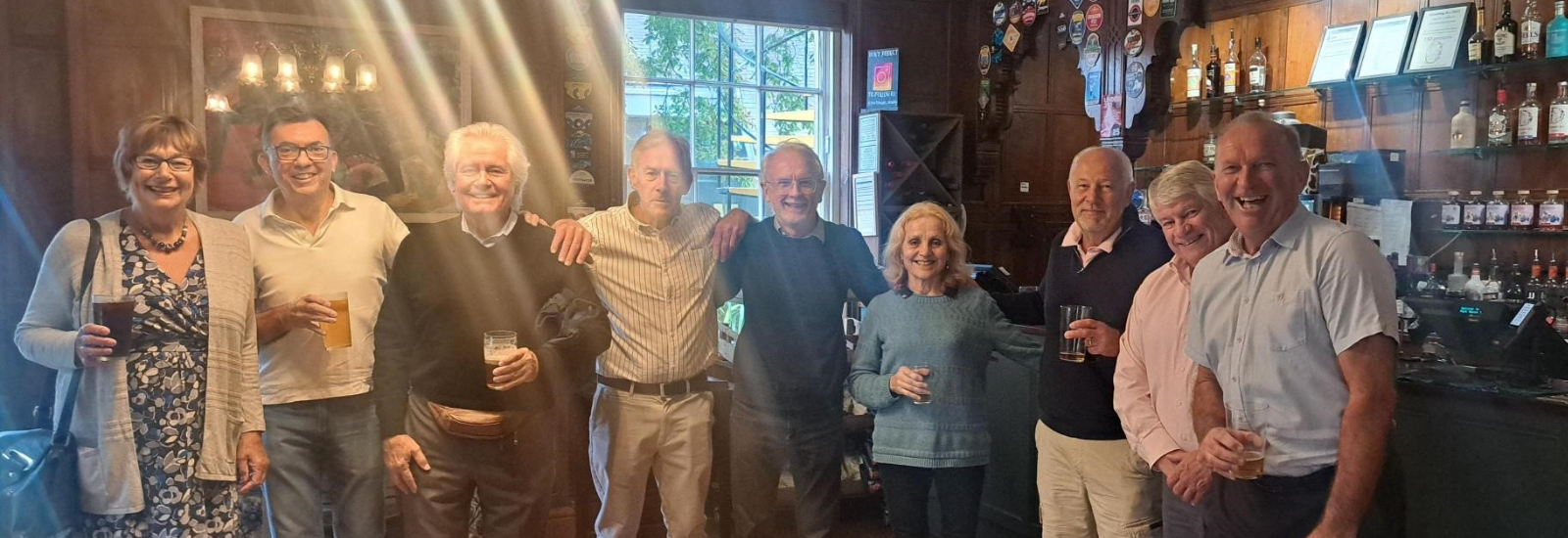 Alumni with arms around shoulders, smiling inside Park House