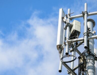 Telecommunications Tower with antennas on blue sky with cloud