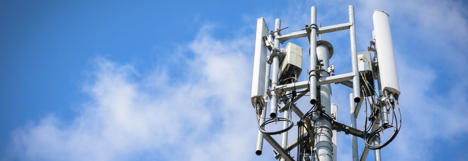 Telecommunications Tower with antennas on blue sky with cloud