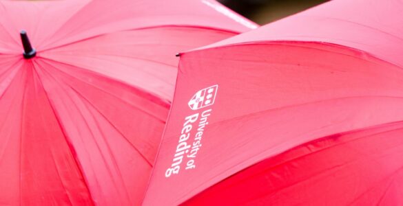 Red umbrellas with the University of Reading logo on