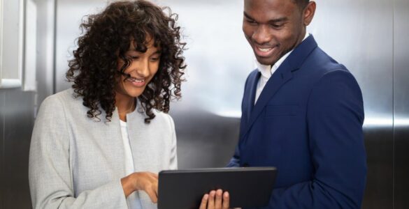 A man and woman looking at an ipad