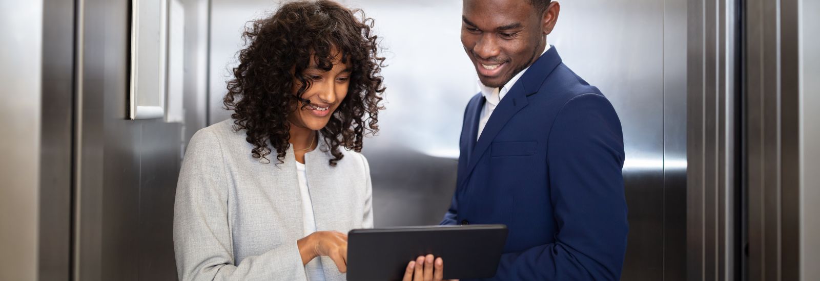 A man and woman looking at an ipad