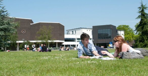 Students sitting on the field outside Palmer Building