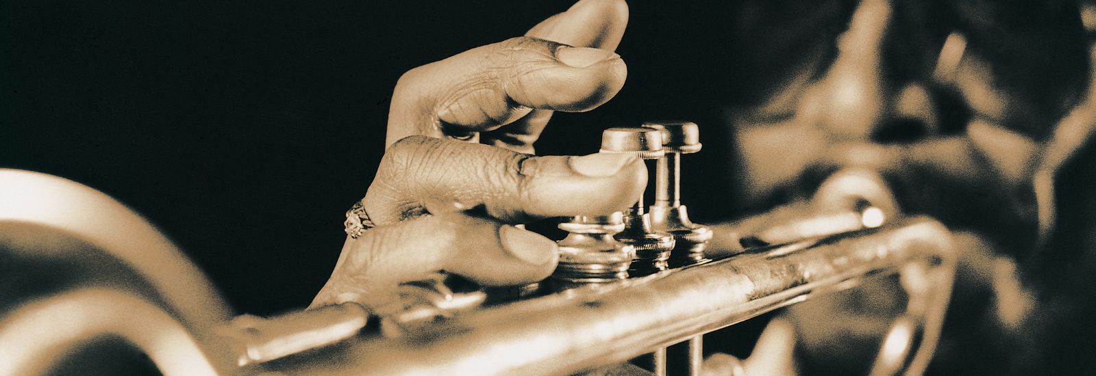 Close-up image of a man playing the trumpet
