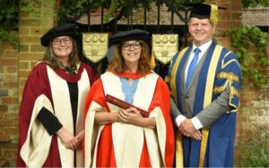 Ruth smiling with University staff members at her honorary degree ceremony
