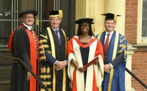 Dorothy smiling with University staff members at her honorary degree ceremony