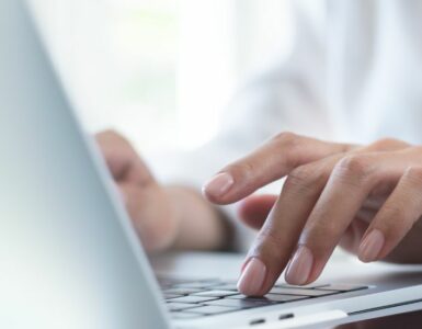 A lady's hands typing on a laptop
