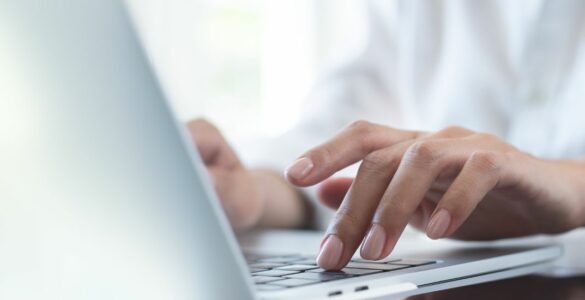 A lady's hands typing on a laptop