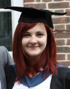 Emma smiling in her graduation cap and gown