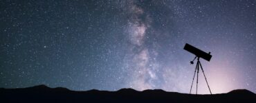 Image of a telescope silhouette on the background of the milky way galaxy.