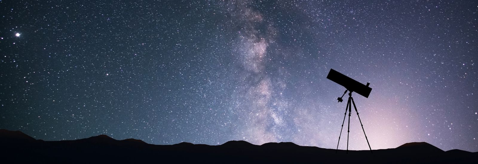 Image of a telescope silhouette on the background of the milky way galaxy.