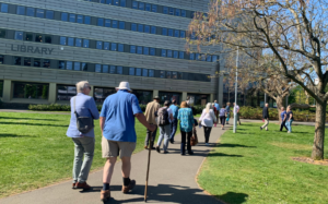 group of alumni facing away from camera walking towards the library