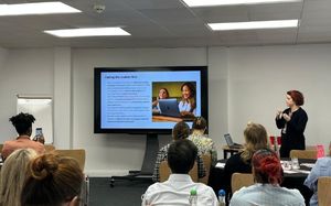 Roseanna at the conference leading a presentation to a room full of people.
