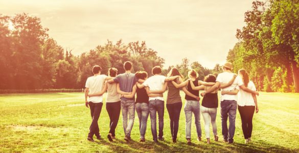 A group of friends walking away with their arms around each other