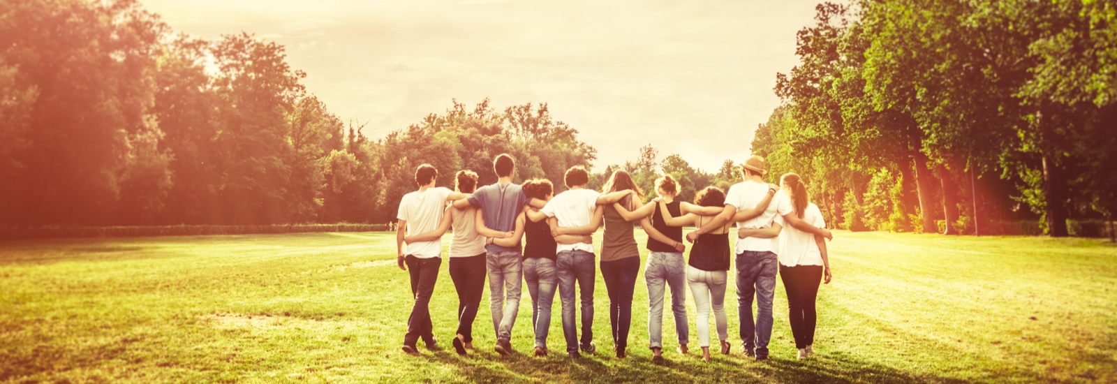A group of friends walking away with their arms around each other