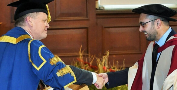 Imran shaking the Vice-Chancellor's hand on his graduation from the University of Reading