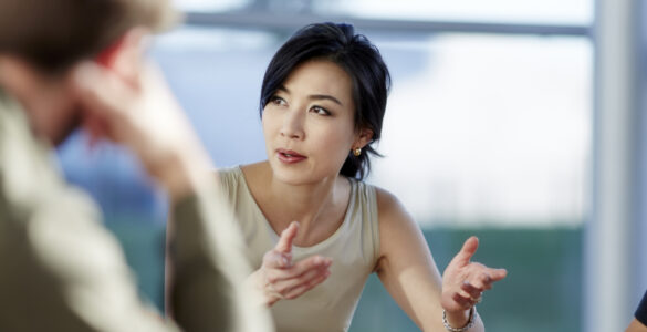 Women speaking to men in a business meeting