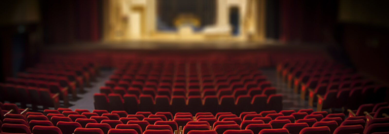 Empty seats in a theatre looking towards the stage