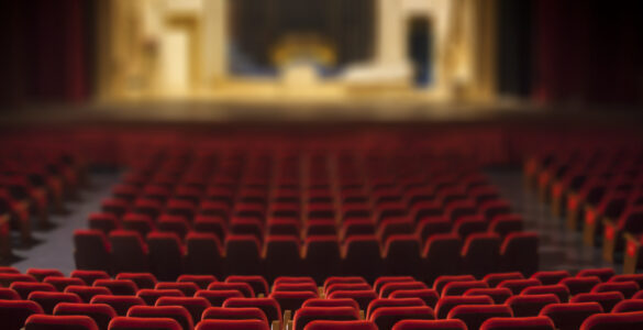 Empty seats in a theatre looking towards the stage