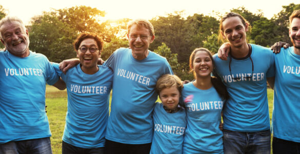 Group of volunteers standing in a line with arms around each other.