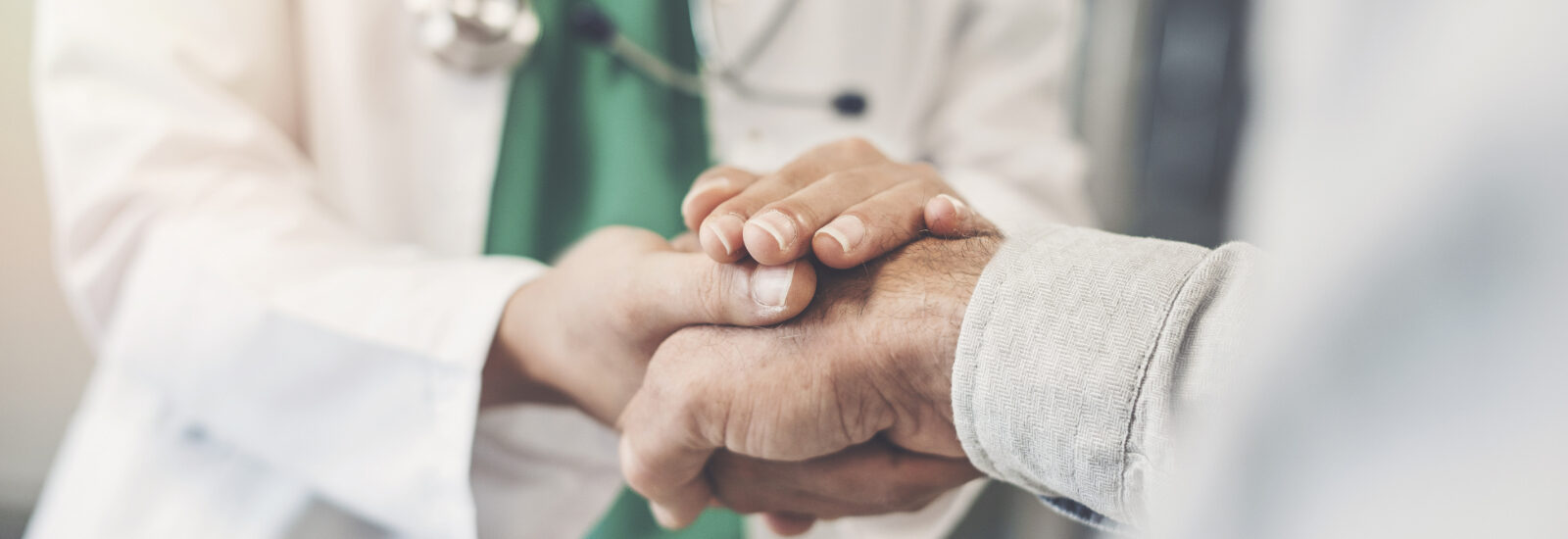 Hospital worker holding a patient's hand